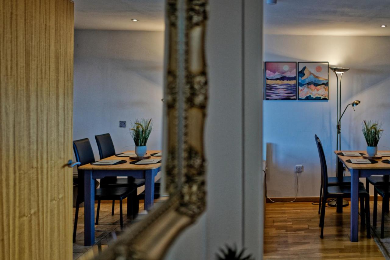 Dining area with tables, chairs and mirror in the apartment